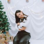 a woman sitting on a bed holding a cat