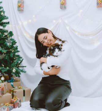 a woman sitting on a bed holding a cat