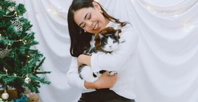 a woman sitting on a bed holding a cat